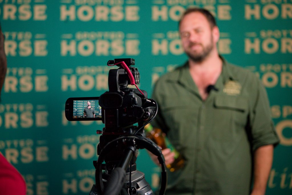 The Stratcom crew filming at the Spotted Horse brand wall